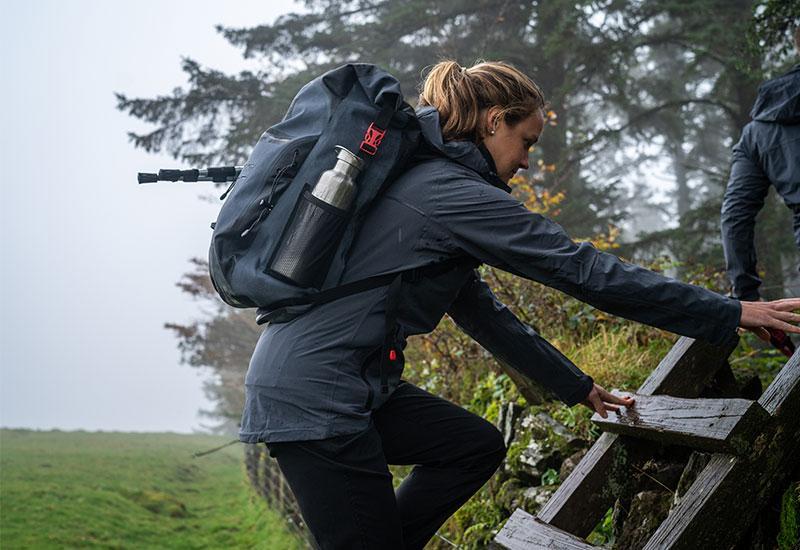 Woman Using a Wooden Ladder To Help Her Get Over A Wall