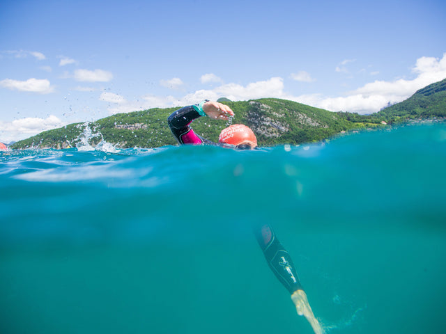 half underwater photo of a man open water swimming
