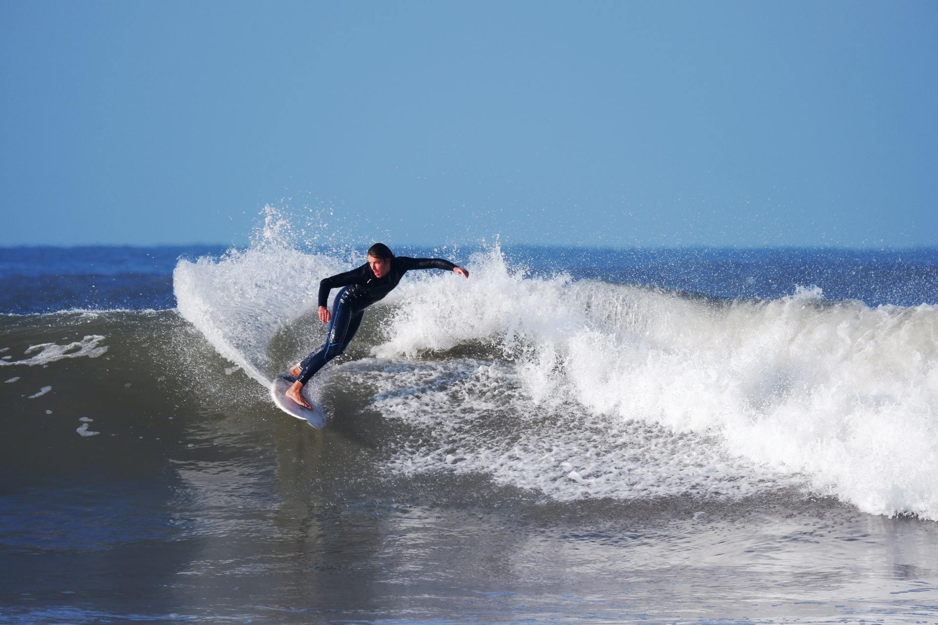 Surfer surfing in the sea in Croyde North Devon wearing a wetsuit